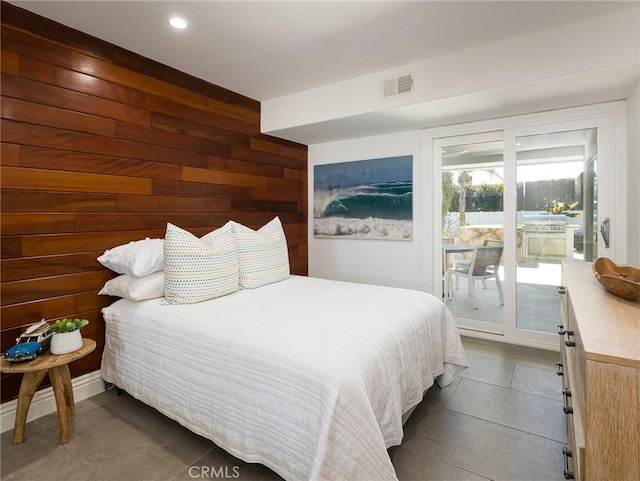 bedroom with access to exterior, visible vents, and wooden walls