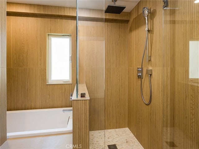 full bathroom featuring walk in shower and a bath