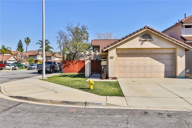 view of front of home featuring a tiled roof, a residential view, fence, and stucco siding