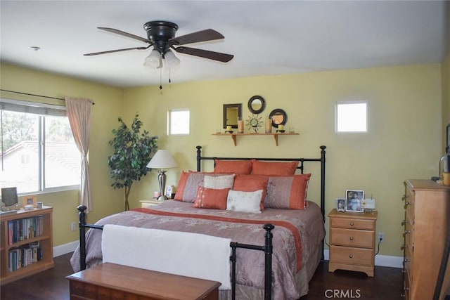 bedroom featuring dark wood-style floors, a ceiling fan, and baseboards