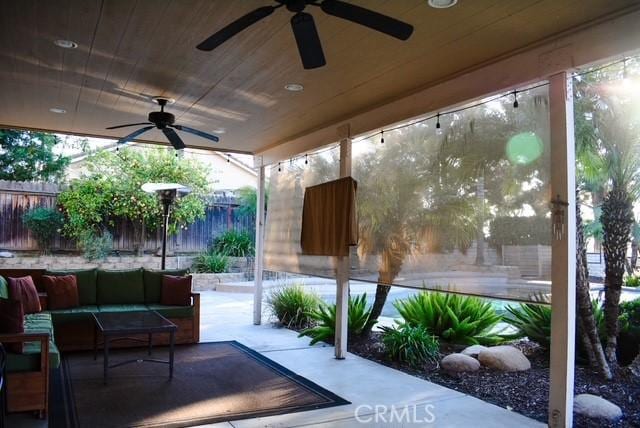 view of patio / terrace with ceiling fan, fence, and an outdoor living space