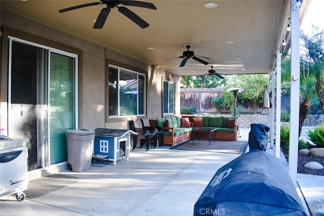 view of patio / terrace featuring fence, an outdoor hangout area, and a ceiling fan