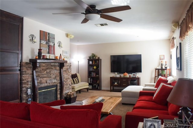 living room featuring a fireplace, carpet flooring, visible vents, and a ceiling fan