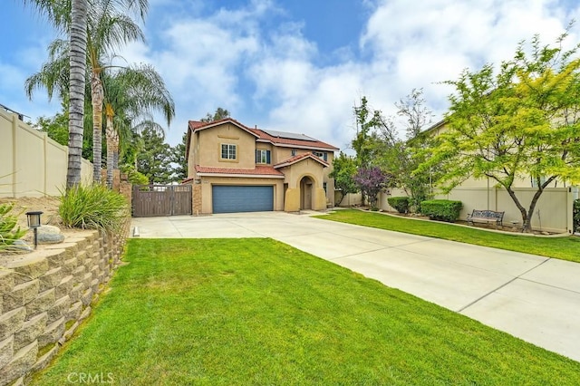 mediterranean / spanish-style home with roof mounted solar panels, driveway, fence, and stucco siding