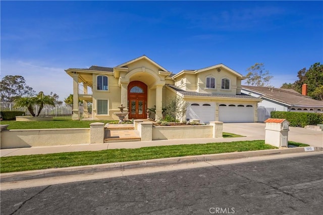 mediterranean / spanish home featuring concrete driveway, an attached garage, fence, and stucco siding