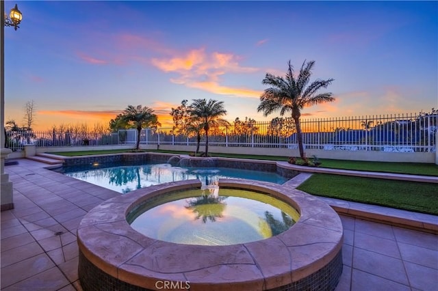 pool at dusk featuring an in ground hot tub, fence, and a fenced in pool