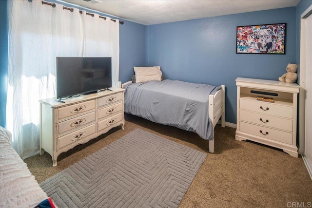 bedroom with dark colored carpet and baseboards