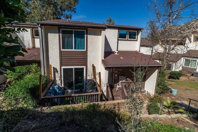 rear view of property featuring stucco siding