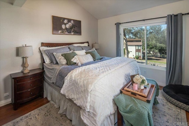 bedroom featuring vaulted ceiling, baseboards, and wood finished floors