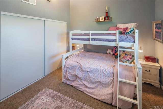 carpeted bedroom with a closet and visible vents