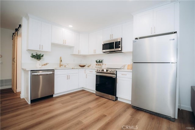 kitchen with light countertops, appliances with stainless steel finishes, and white cabinetry