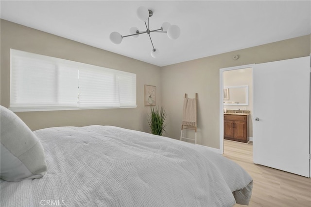 bedroom featuring ensuite bathroom and light wood-type flooring