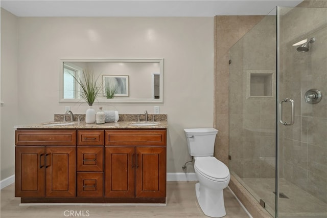 bathroom with toilet, a shower stall, and a sink