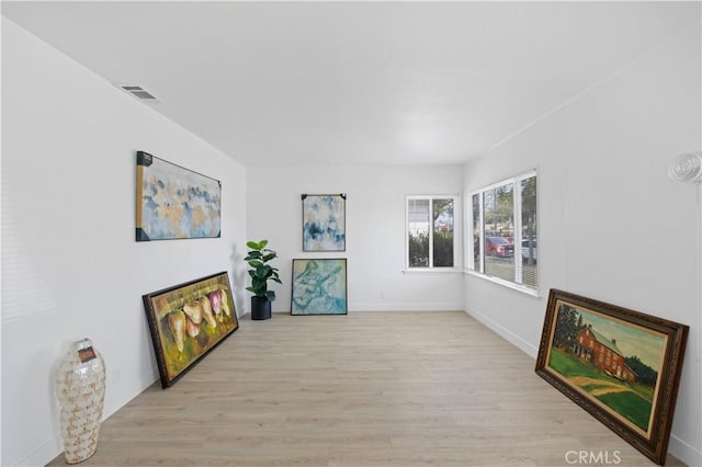 sitting room featuring light wood finished floors, baseboards, and visible vents