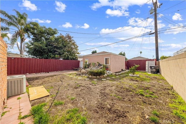 view of yard with a fenced backyard, an outdoor structure, central AC, and a storage shed