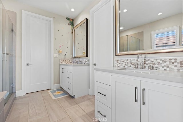 bathroom featuring recessed lighting, two vanities, a sink, and a shower stall