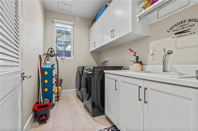 washroom with cabinet space, a sink, washer and clothes dryer, and baseboards