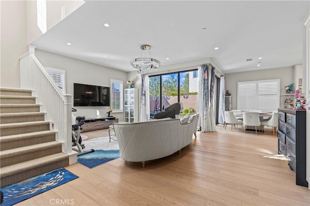 living room featuring light wood-style floors, stairs, and recessed lighting