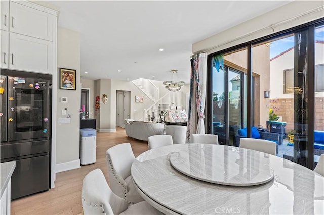 dining space featuring light wood-type flooring, stairway, baseboards, and recessed lighting