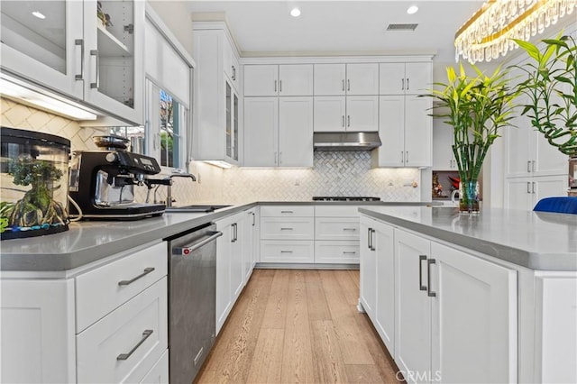 kitchen with dishwasher, under cabinet range hood, visible vents, and white cabinets