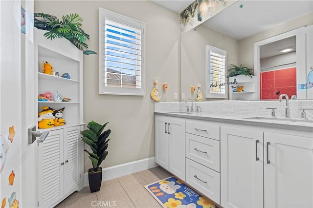 full bathroom with double vanity, a sink, and baseboards