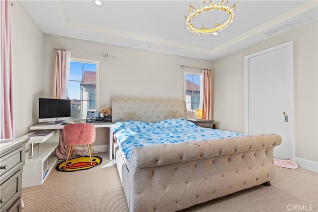 bedroom featuring multiple windows, a raised ceiling, and visible vents