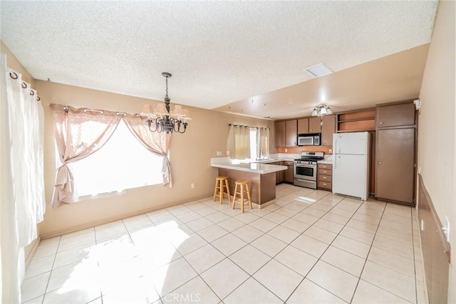 kitchen featuring appliances with stainless steel finishes, light countertops, a wealth of natural light, and light tile patterned flooring