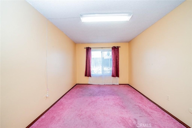 unfurnished room with baseboards and light colored carpet