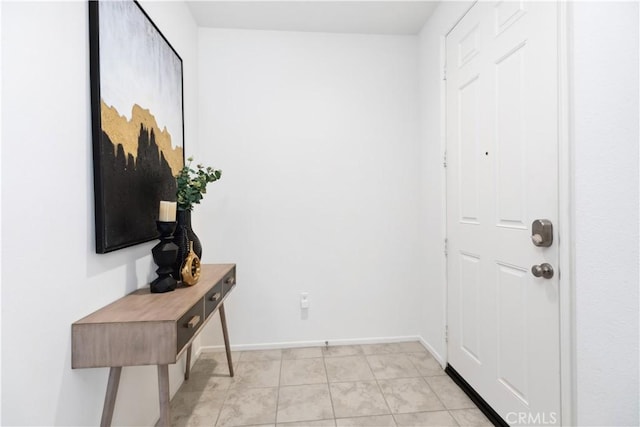 foyer entrance with light tile patterned floors and baseboards