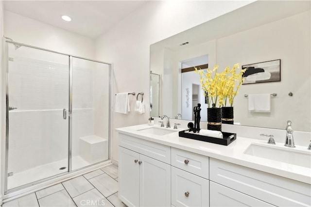 full bathroom featuring double vanity, a sink, and a shower stall