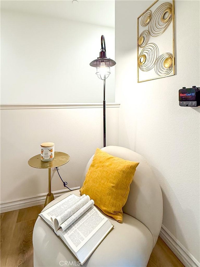 sitting room featuring baseboards and wood finished floors