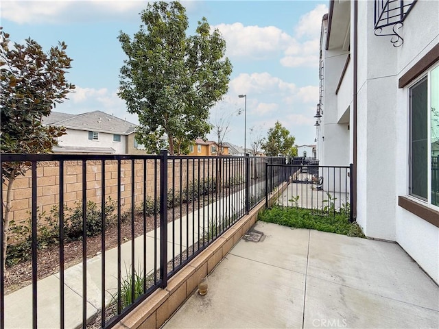 exterior space featuring a residential view, fence, and a balcony