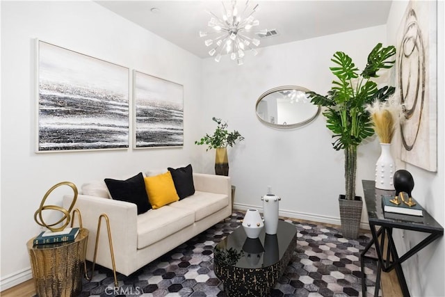 living area featuring baseboards, visible vents, and a notable chandelier