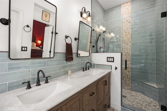 ensuite bathroom featuring double vanity, a sink, connected bathroom, and a shower stall