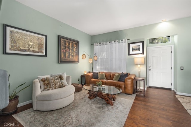 living area featuring dark wood-style flooring and baseboards