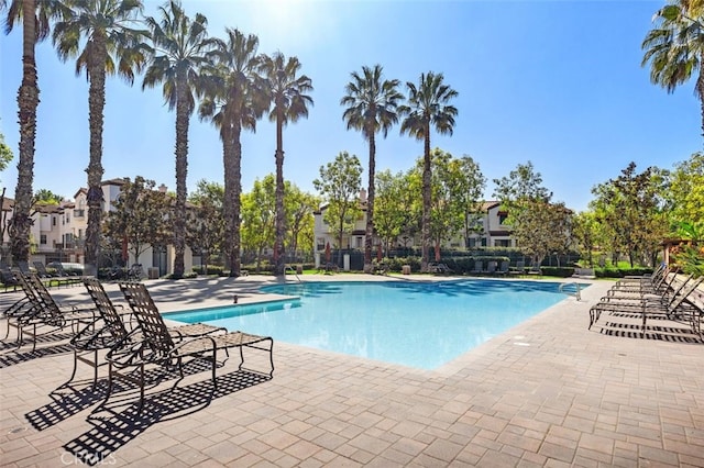 pool featuring a patio area, fence, and a residential view