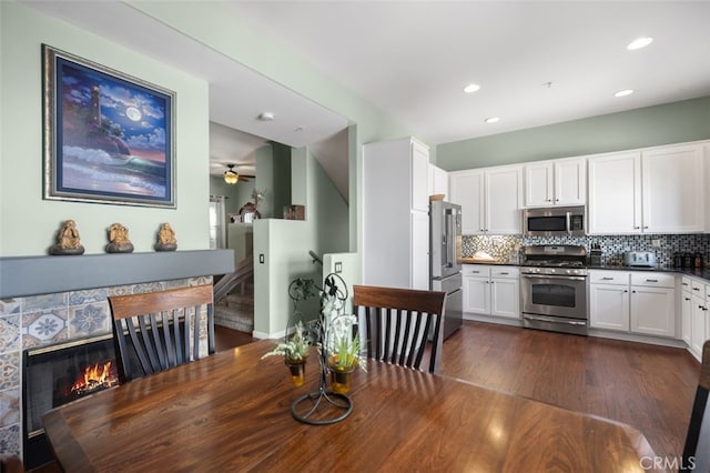 dining area with a ceiling fan, dark wood finished floors, a fireplace, and recessed lighting