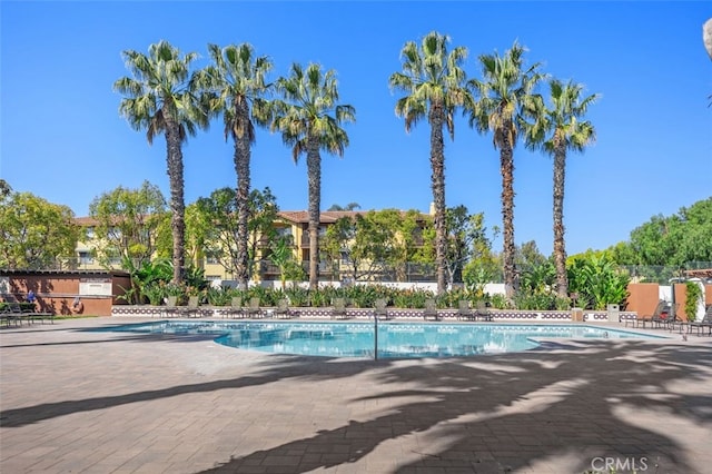 community pool with fence and a patio