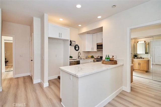 kitchen with baseboards, appliances with stainless steel finishes, light wood-type flooring, white cabinetry, and recessed lighting