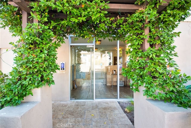 doorway to property featuring stucco siding