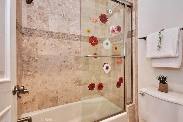 bathroom with shower / bath combination with glass door and toilet