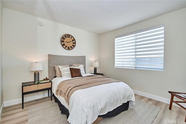 bedroom with light wood-style floors and baseboards