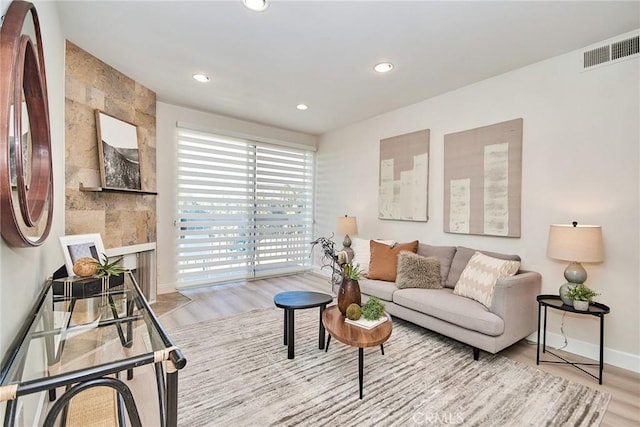 living area featuring light wood-type flooring, baseboards, visible vents, and recessed lighting