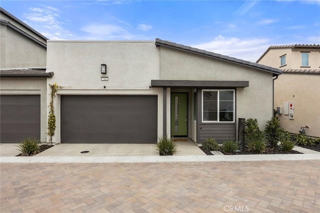 view of front of home with decorative driveway and stucco siding