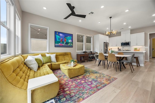 living area featuring light wood finished floors, visible vents, and recessed lighting