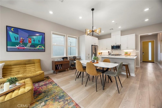 dining space featuring baseboards, recessed lighting, and light wood-style floors