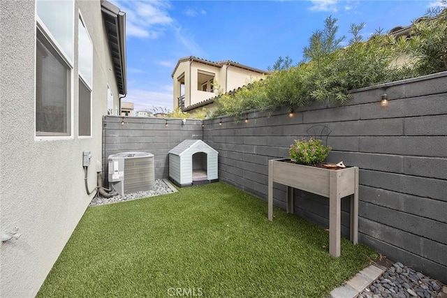 view of yard with central AC and a fenced backyard