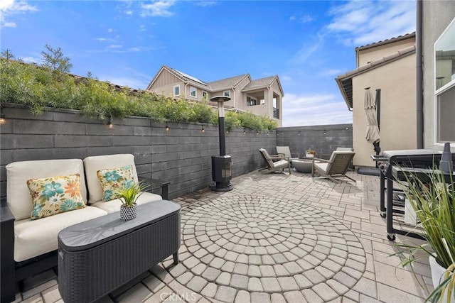 view of patio featuring an outdoor living space with a fire pit and a fenced backyard