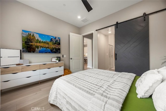 bedroom featuring a barn door, recessed lighting, visible vents, a ceiling fan, and light wood-type flooring