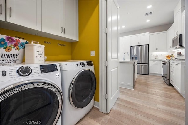 clothes washing area with laundry area, visible vents, independent washer and dryer, light wood-type flooring, and recessed lighting